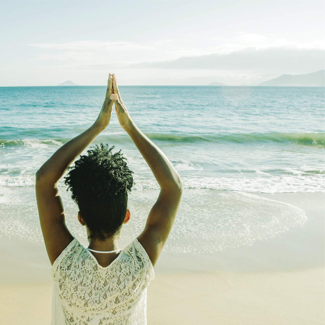 african woman on beach practicing yoga as a healthy lifestyle choice